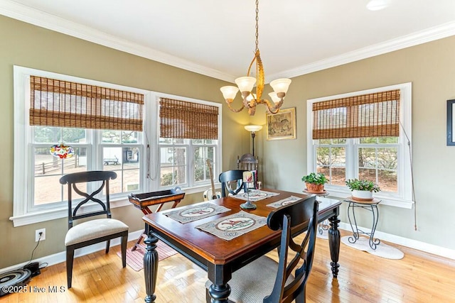 dining area with a wealth of natural light, crown molding, and light wood finished floors