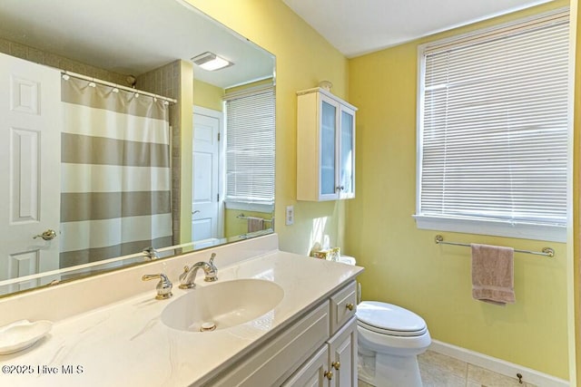 bathroom featuring toilet, tile patterned flooring, baseboards, and vanity