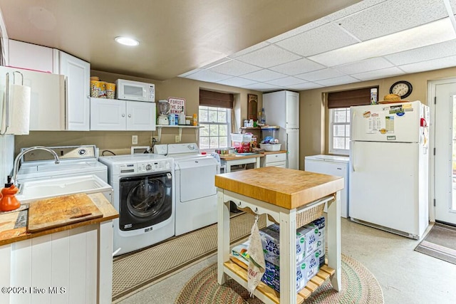 laundry room with a sink, a healthy amount of sunlight, and washer and dryer