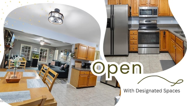 103 Ridge Rd, Hampstead, NC 28443 - kitchen with stainless steel appliances, light tile patterned floors, brown cabinetry, dark countertops, and open floor plan