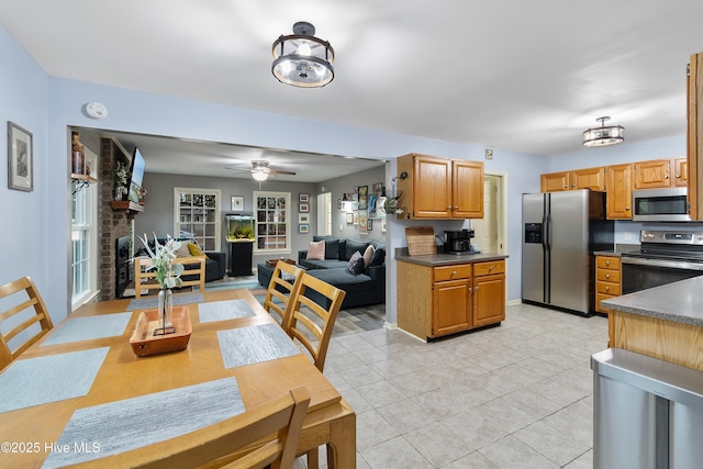 103 Ridge Rd, Hampstead, NC 28443 - kitchen with stainless steel appliances, dark countertops, light tile patterned floors, and a ceiling fan