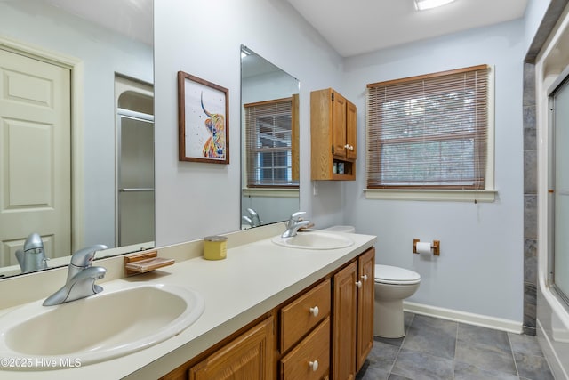 103 Ridge Rd, Hampstead, NC 28443 - bathroom with a shower with door, baseboards, double vanity, and toilet