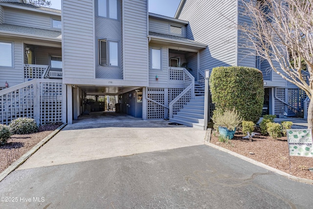 exterior space with a carport, stairway, and concrete driveway