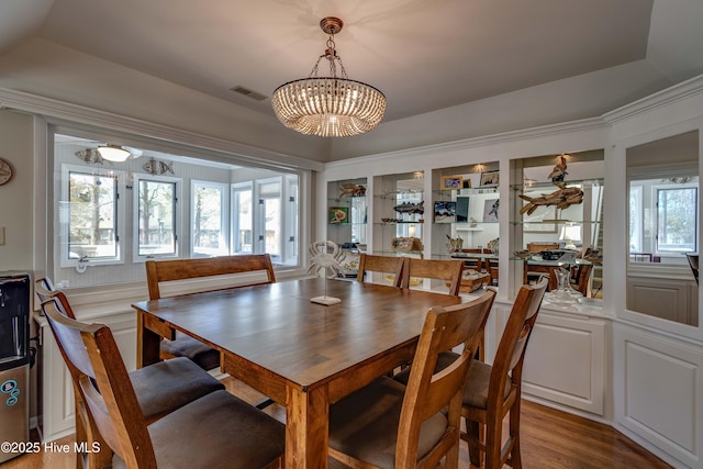 dining space with visible vents, wood finished floors, and a chandelier