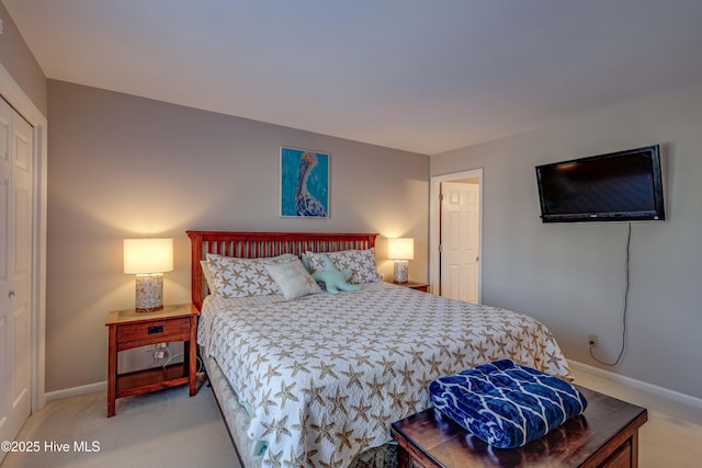 bedroom with light colored carpet and baseboards