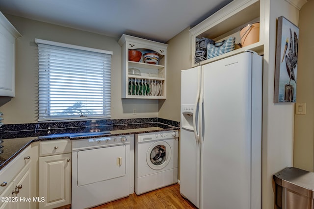 kitchen with dark stone counters, open shelves, white refrigerator with ice dispenser, light wood-style flooring, and white cabinetry