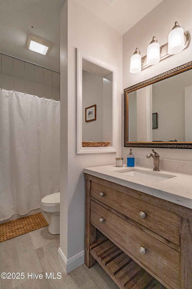 bathroom featuring vanity, toilet, and a shower with shower curtain