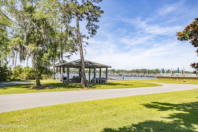surrounding community featuring a lawn, a gazebo, and a water view