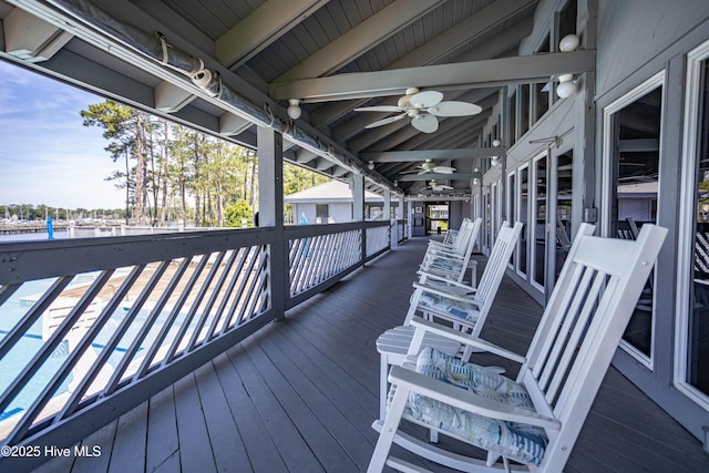 wooden deck featuring a swimming pool and a ceiling fan