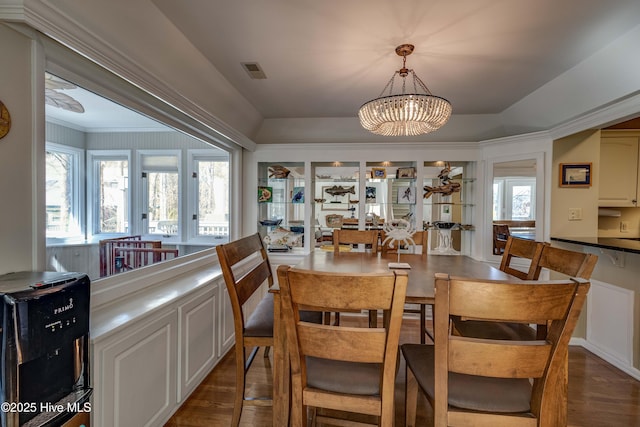 dining room with dark wood-style floors, visible vents, and a notable chandelier