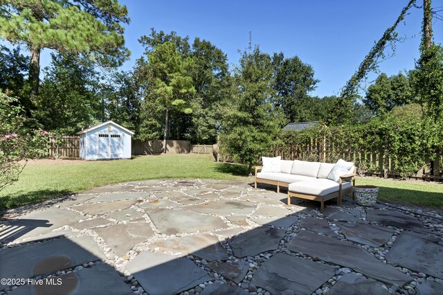 view of patio / terrace featuring a storage shed, an outdoor structure, a fenced backyard, and an outdoor living space