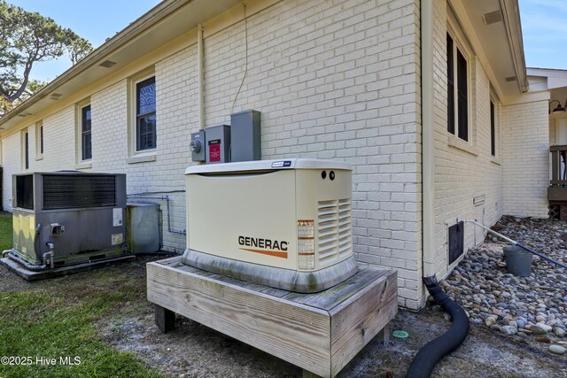 exterior details featuring brick siding, a power unit, and electric meter