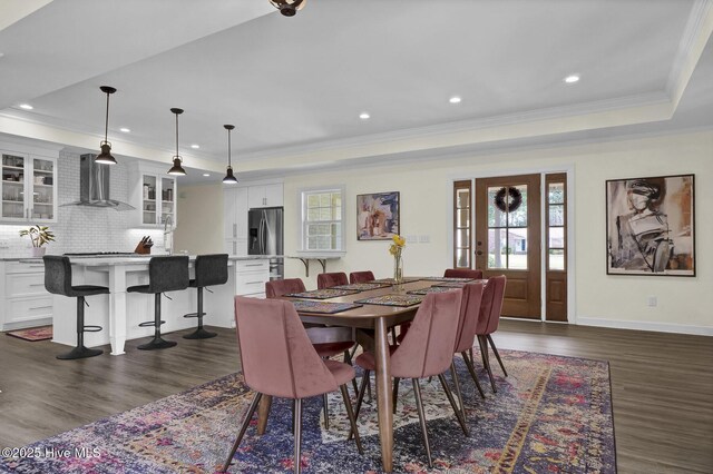 dining area featuring baseboards, a tray ceiling, ornamental molding, recessed lighting, and dark wood-style floors