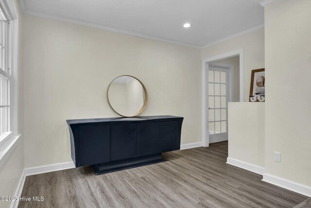unfurnished room featuring baseboards, wood finished floors, and crown molding
