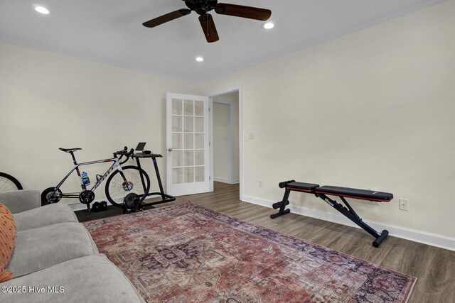 exercise area with a ceiling fan, wood finished floors, baseboards, recessed lighting, and ornamental molding