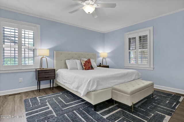 bedroom featuring crown molding, baseboards, and wood finished floors
