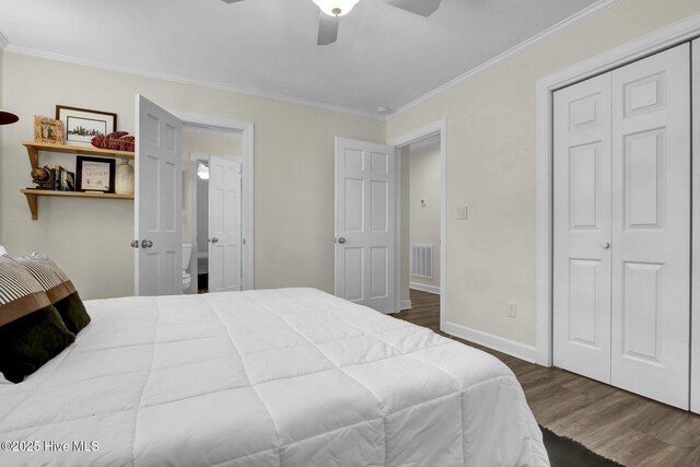 bedroom with visible vents, baseboards, wood finished floors, and crown molding