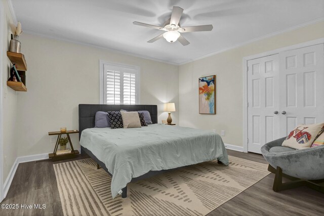 bedroom with dark wood-type flooring, baseboards, and ornamental molding