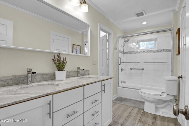 bathroom with a sink, visible vents, toilet, and ornamental molding