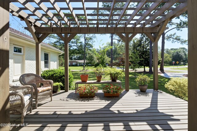 deck featuring a lawn and a pergola