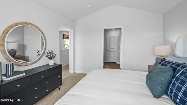 carpeted bedroom with lofted ceiling