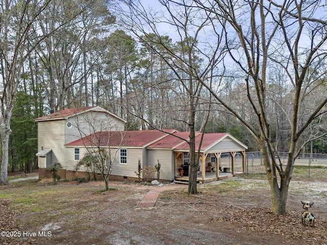 view of front of property with fence and crawl space