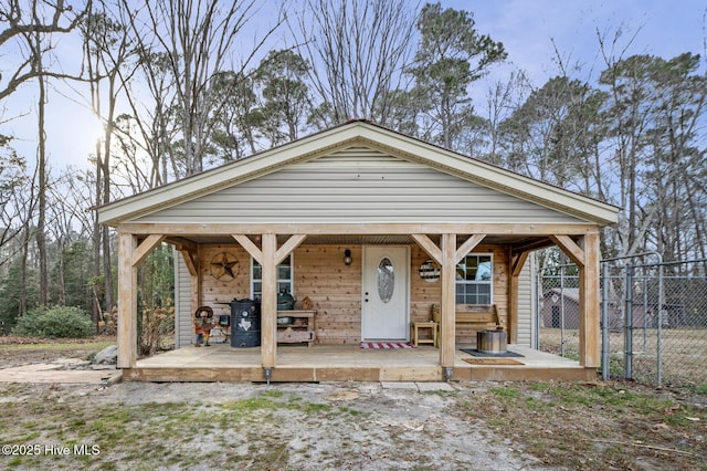 view of front of house with a gate, a porch, and fence