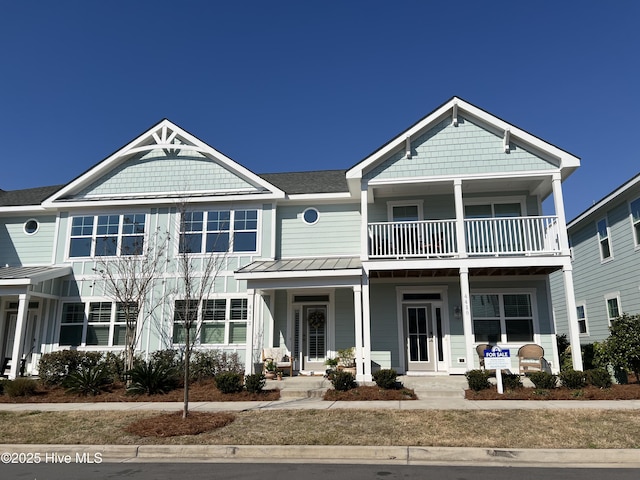 townhome / multi-family property featuring covered porch, a balcony, and a standing seam roof