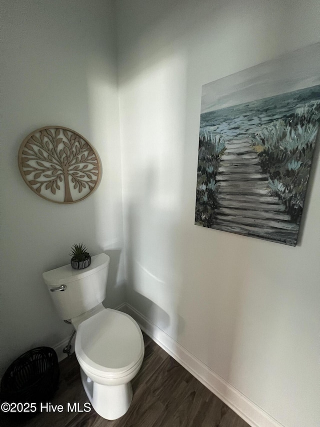 bathroom with baseboards, toilet, and wood finished floors