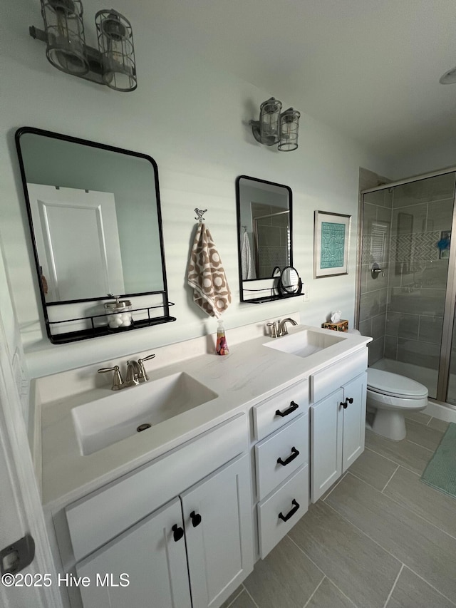 bathroom with a sink, a shower stall, and double vanity