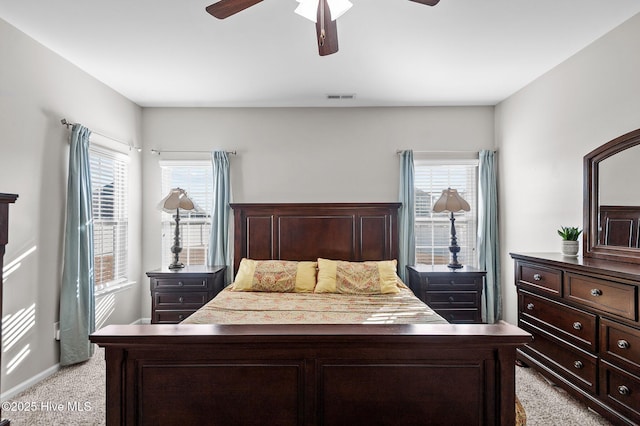 bedroom featuring ceiling fan, multiple windows, visible vents, and light colored carpet