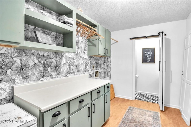 kitchen featuring a textured ceiling, light hardwood / wood-style floors, and green cabinetry