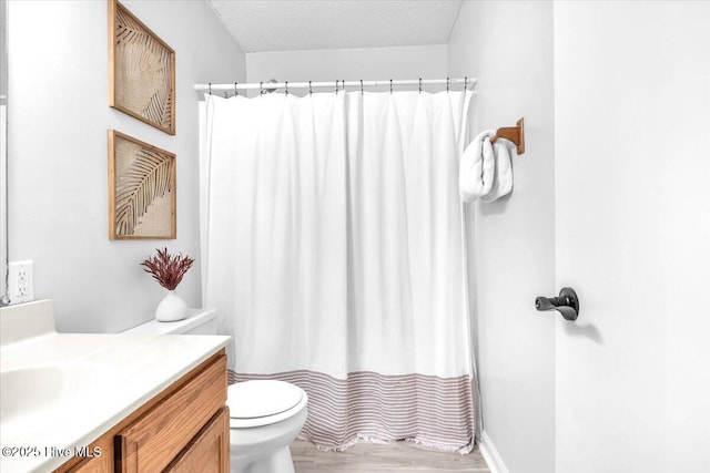 bathroom with toilet, a shower with curtain, wood-type flooring, a textured ceiling, and vanity