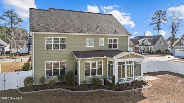 rear view of property featuring a sunroom