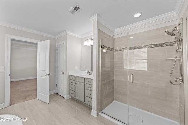 bathroom with crown molding, an enclosed shower, and vanity