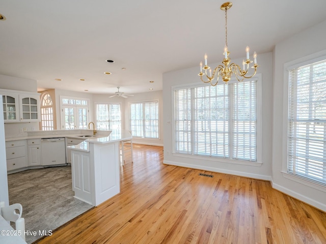 kitchen with dishwasher, a sink, a wealth of natural light, and light wood-style floors