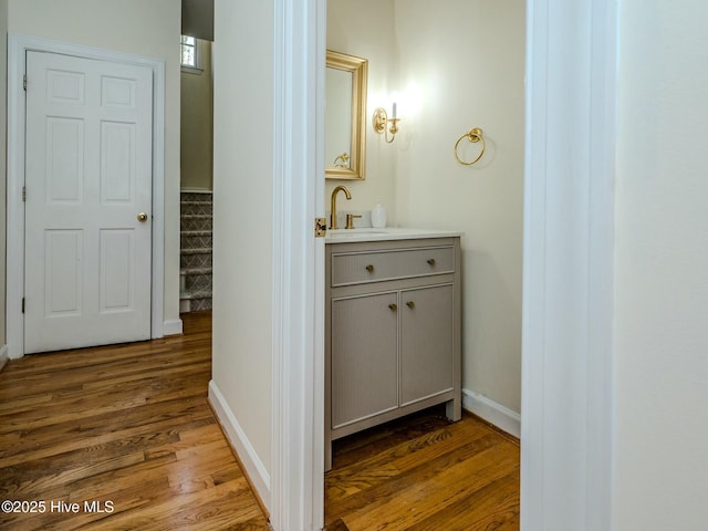 bathroom featuring baseboards, wood finished floors, and vanity