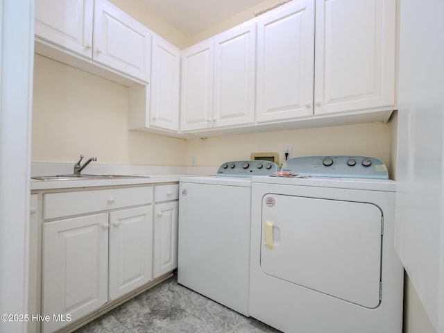 washroom featuring independent washer and dryer, a sink, and cabinet space