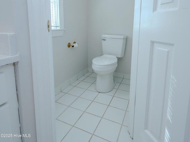 bathroom with toilet, baseboards, and tile patterned floors