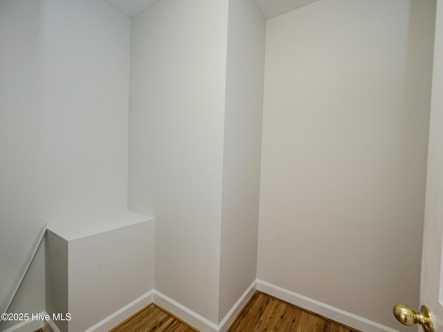 clothes washing area featuring light wood-style flooring and baseboards