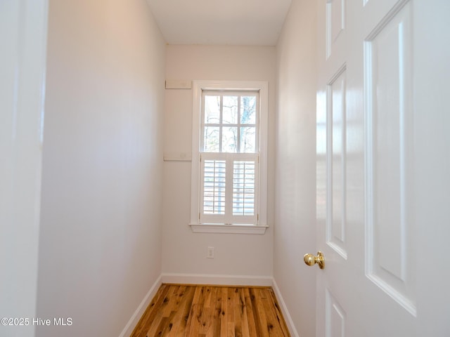 doorway to outside featuring baseboards and wood finished floors