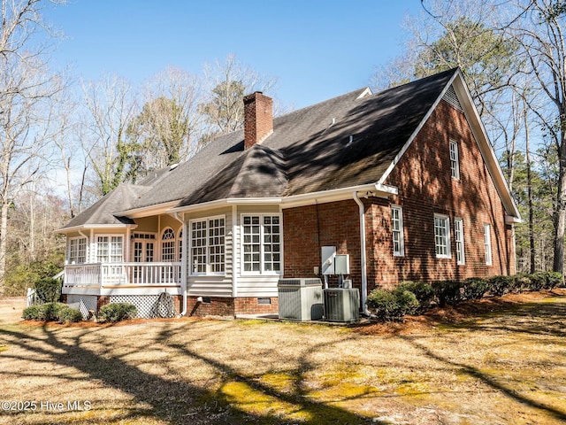 back of house featuring a chimney, crawl space, a deck, central AC, and brick siding