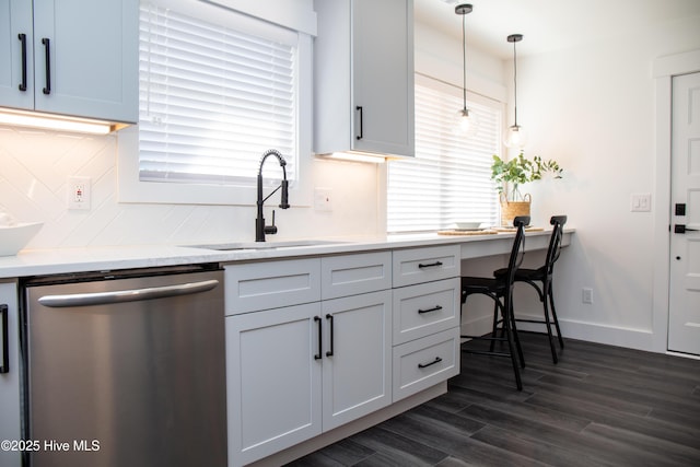 kitchen featuring sink, white cabinetry, decorative backsplash, decorative light fixtures, and stainless steel dishwasher