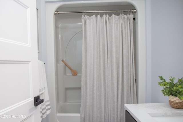 bathroom featuring vanity and shower / bathtub combination with curtain