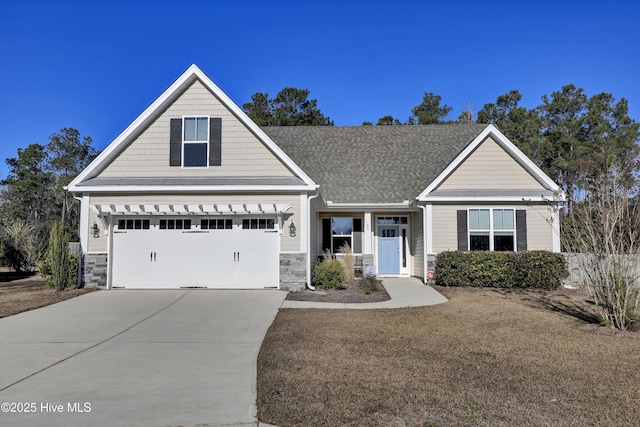 view of front facade featuring stone siding, concrete driveway, and roof with shingles