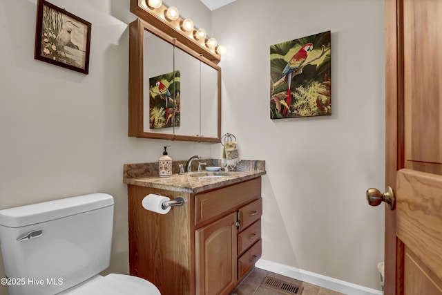 bathroom with toilet, baseboards, visible vents, and vanity