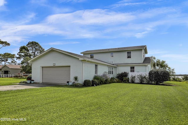 exterior space with a front yard, concrete driveway, brick siding, and an attached garage