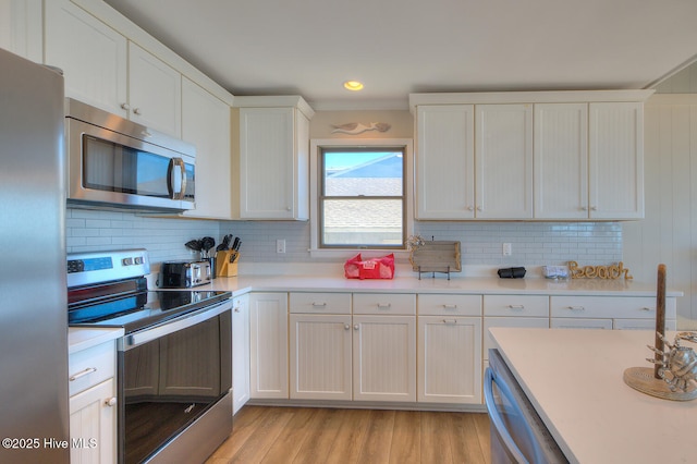 kitchen with white cabinetry, tasteful backsplash, and stainless steel appliances