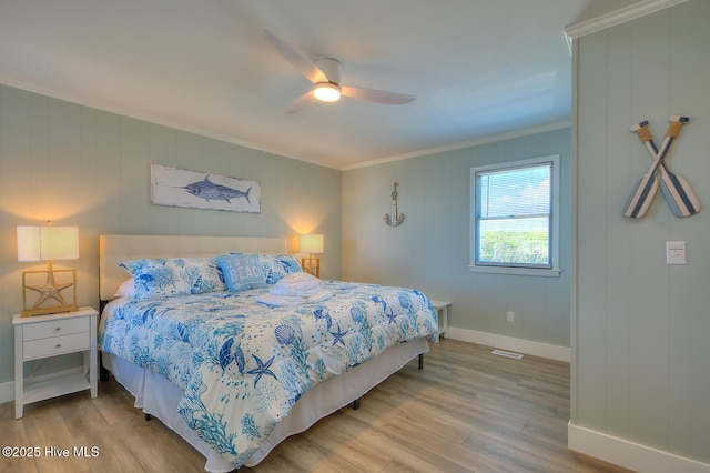 bedroom with ornamental molding, ceiling fan, and light wood-type flooring