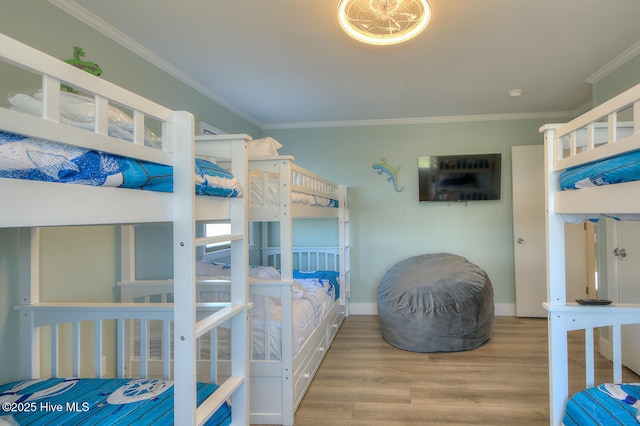 bedroom with wood-type flooring and ornamental molding